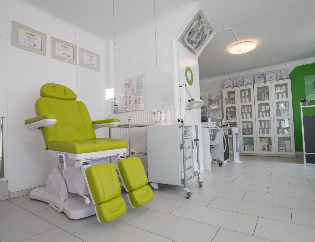 Professional equipment in doctor office with couch for medical treatment procedures behind protective screen
